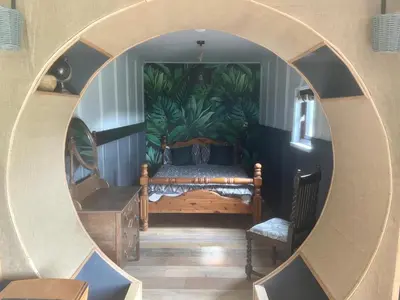 a room with a couch and a mirror at Acorn Warren in Welshpool