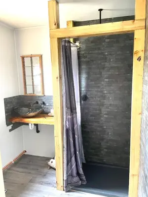 a loft bed in a room with a brick wall at Acorn Warren in Welshpool