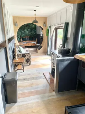 a living room with a kitchen and a living room with a couch at Acorn Warren in Welshpool