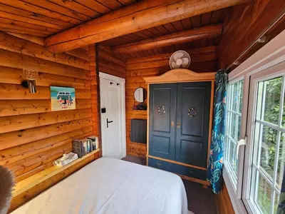 a bedroom with a bed in a wooden house at Bryn Cnocell in Trawsfynydd