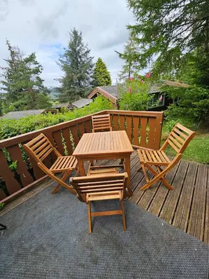 a wooden table and two chairs on a deck at Bryn Cnocell in Trawsfynydd