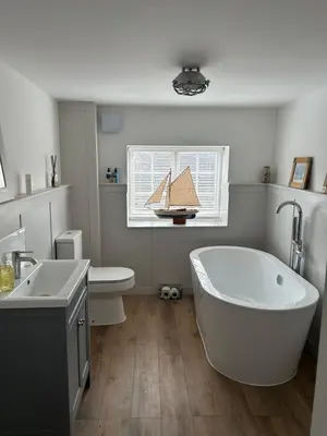 a bathroom with a tub and a boat in a window at The Hat Works in Ludlow