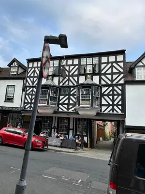 a black and white building with a red car parked in front at The Hat Works in Ludlow