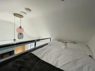 a bedroom with a white bed and a window at Little Cottage of the Beacons in Brecon