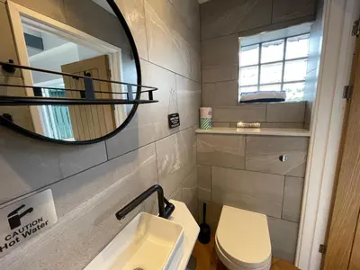 a bathroom with a sink and a mirror and a toilet at Little Cottage of the Beacons in Brecon