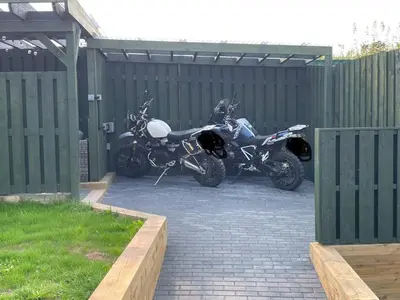two motorcycles parked in a parking lot next to a fence at Little Cottage of the Beacons in Brecon
