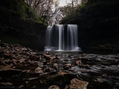 a waterfall in the middle of a river at Little Cottage of the Beacons in Brecon