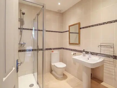 a bathroom with a toilet and a sink and a shower at Tonnau Yr Oleu or Waves of Light in Barmouth