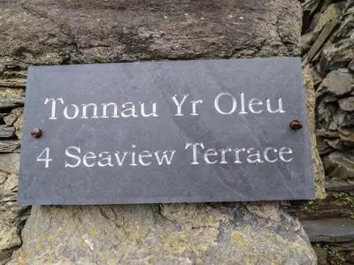 a sign on the side of a rock at Tonnau Yr Oleu or Waves of Light in Barmouth