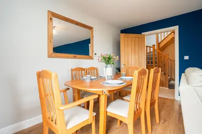 a dining room with a wooden table and chairs at Carreg Wen in Harlech