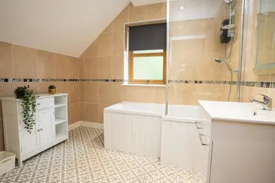 a bathroom with a tub and a sink at Carreg Wen in Harlech
