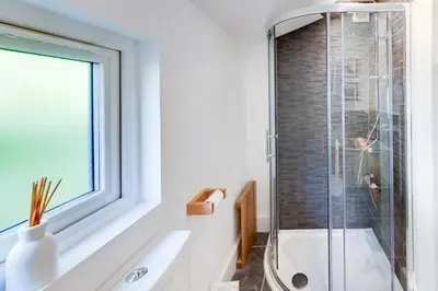 a bathroom with a shower and a sink and a window at 5 Bed in Aberdovey oc-t29402 in Aberdyfi