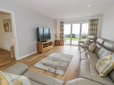 a living room with a couch and a flat screen tv at Melin Y Plas in Barmouth