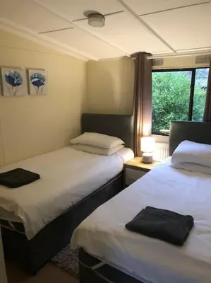 a room with two beds and a window in it at 5f Stanley Lodge, Caer Beris, Builth Wells - No tradesman in Builth Wells