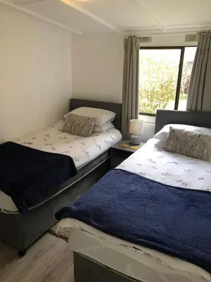 two beds in a room with a window at 5f Stanley Lodge, Caer Beris, Builth Wells - No tradesman in Builth Wells