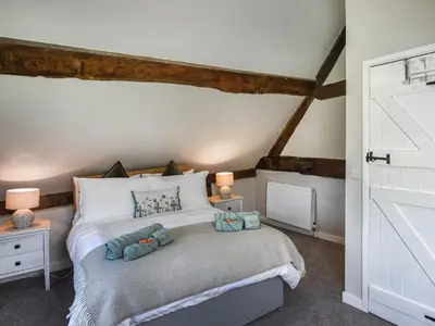 a bedroom with a bed with two teddy bears on it at Ty-Ucha Cottage in Llangollen