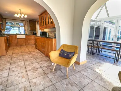a kitchen with an archway and a chair with a pillow at The Willows in Llangollen