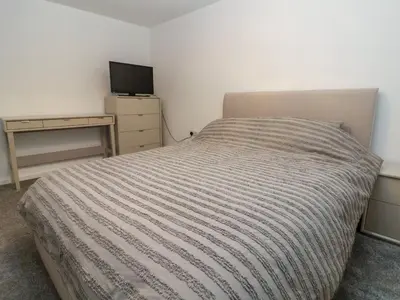 a bedroom with a bed and a desk with a television at The Willows in Llangollen