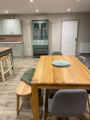 a kitchen with a wooden table and some chairs at Llety Cynnes in Machynlleth