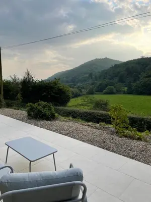a table and a couch on a patio with a view at Llety Cynnes in Machynlleth