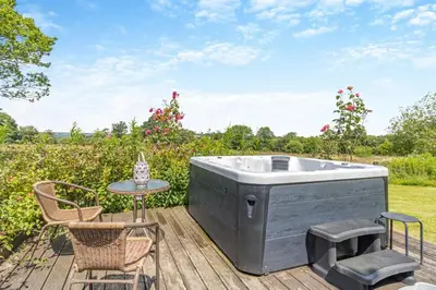a hot tub on a deck with a table and chairs at 3 Bed in Llwynygroes oc-t29715 in Llangeitho