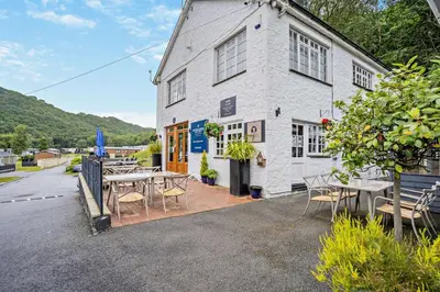 a restaurant with tables and chairs in front of a building at 2 Bed in Gilfachrheda oc-o29754 in Llanina