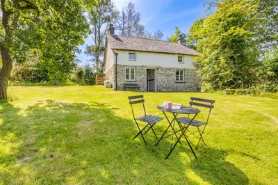 a table and chairs in front of a house at 4 Bed in Llwynygroes oc-y29715 in Llangeitho