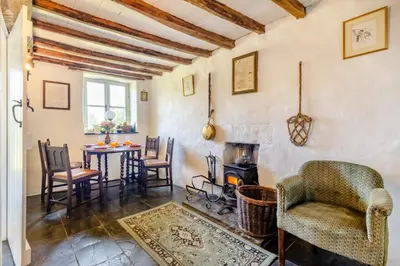 a living room with a table and chairs and a stove at 4 Bed in Llwynygroes oc-y29715 in Llangeitho