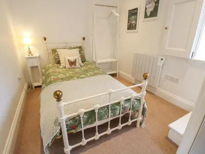 a bedroom with a white bed in a room at Moorhen Cottage in Ludlow