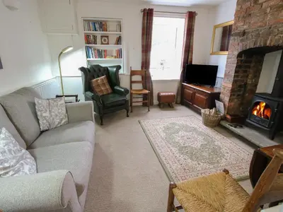 a living room with a couch and a fireplace at Moorhen Cottage in Ludlow
