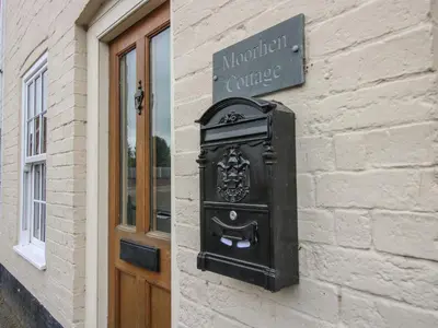 a black mailbox on the side of a building at Moorhen Cottage in Ludlow