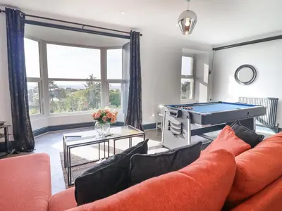 a living room with a couch and a pool table at Gwynfa in Barmouth