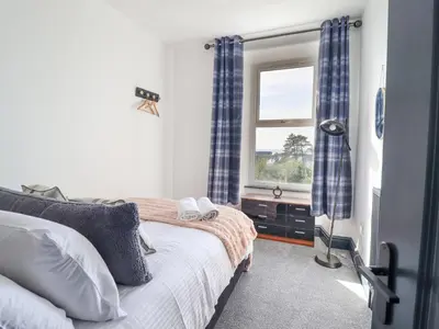 a bedroom with a bed and a window at Gwynfa in Barmouth