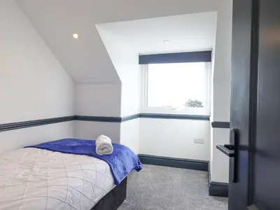 a small bedroom with a bed and a window at Gwynfa in Barmouth