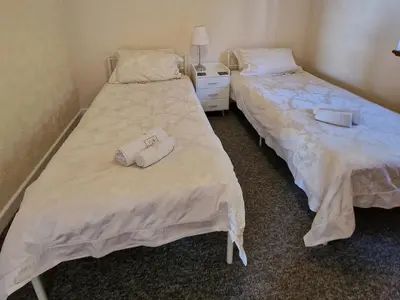 two beds sitting next to each other in a room at Woodland Roost in Barmouth
