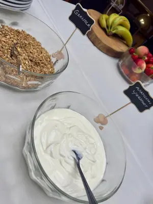 a table with a bowl of yogurt and a bowl of fruit at Cross Hands Hotel in Llanybydder