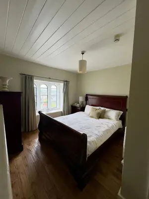 a bedroom with a large bed in a room at Cross Hands Hotel in Llanybydder