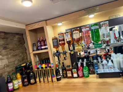 a bar with a bunch of bottles of alcohol at Cross Hands Hotel in Llanybydder