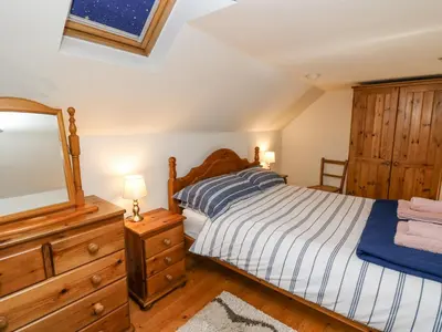 a bedroom with a bed and a dresser and a mirror at Ty Bach Twt in Llandysul