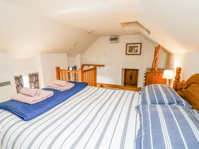 a bedroom with two beds with pink towels on them at Ty Bach Twt in Llandysul