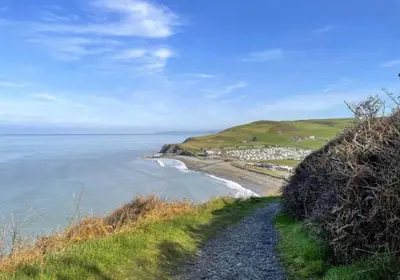 a gravel path next to the ocean on a hill at Sea View Caravan - Aber Bay Holiday Park in Aberystwyth