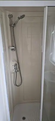 a shower with a shower head in a bathroom at Sea View Caravan - Aber Bay Holiday Park in Aberystwyth