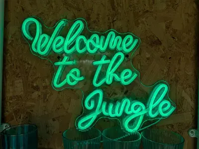 a neon sign that reads welcome to the jungle at Kestrel lodge in Wrexham
