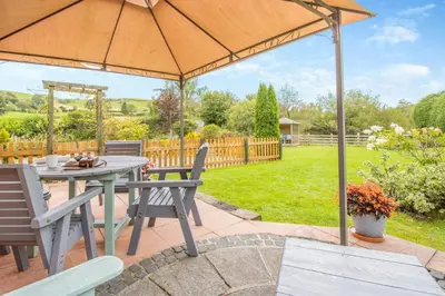a patio with a table and chairs and an umbrella at 2 Bed in Devils Bridge oc-d29575 in Devils Bridge