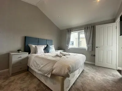 a bedroom with a large bed and a window at WH - Smugglers Lodge in Aberaeron