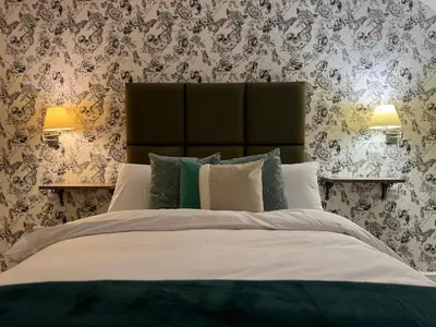 a bedroom with a large bed with floral wallpaper at Class Stays in Shrewsbury