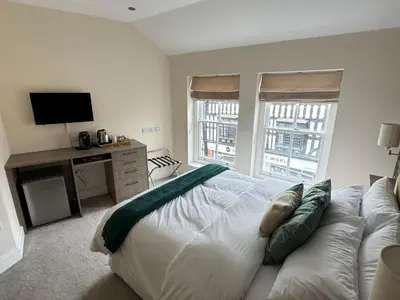 a bedroom with a white bed and a television at Class Stays in Shrewsbury