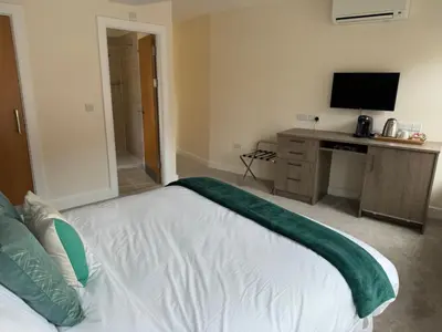 a bedroom with a bed and a desk with a television at Class Stays in Shrewsbury