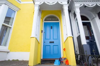 a blue door on a yellow and white building at Trem y Don New Quay in New Quay