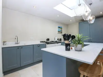a kitchen with blue cabinets and a white counter top at Islwyn in Bala